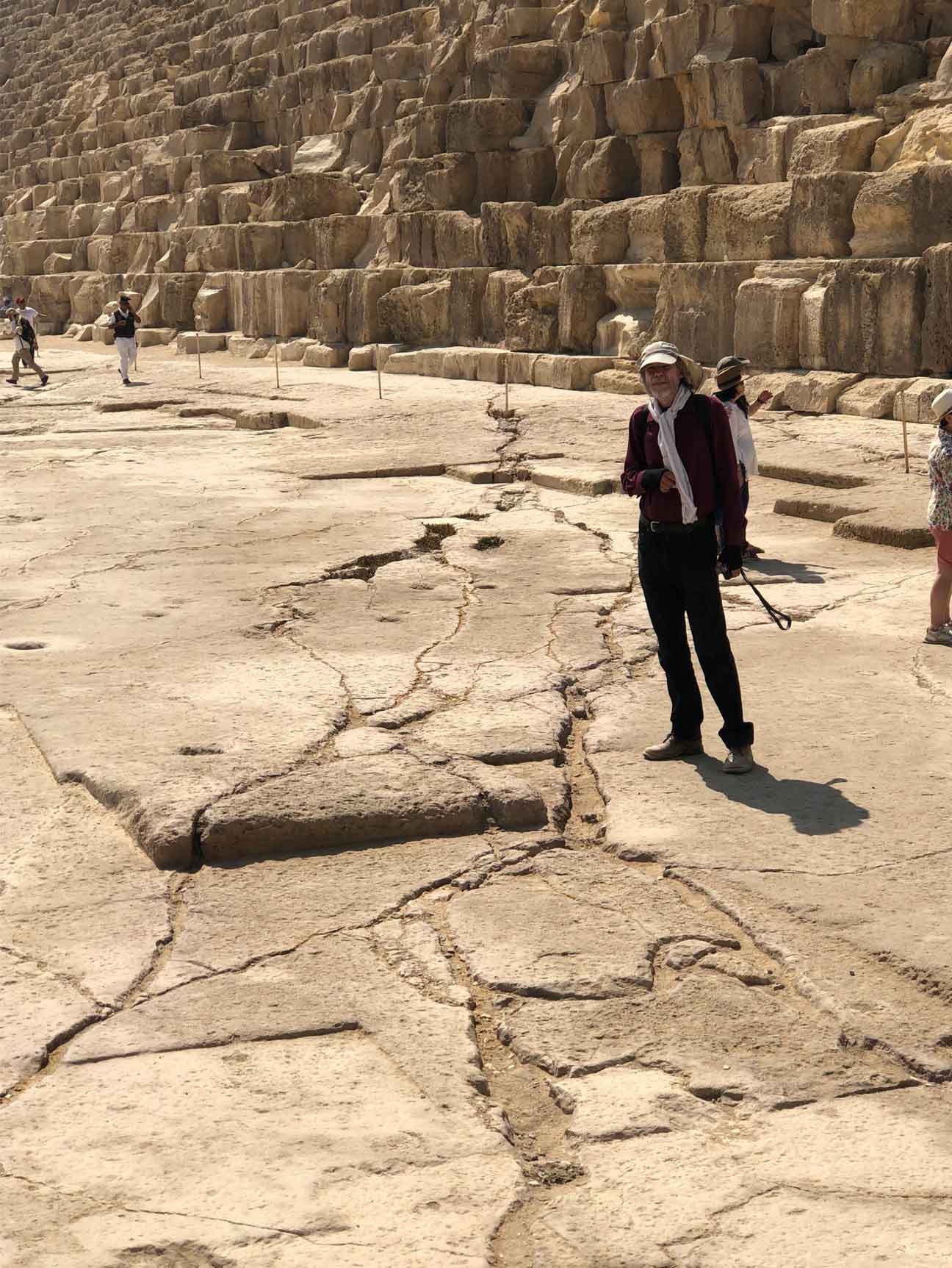 Robert Schoch standing in front of the Great Pyramid and near evidence of a lightning strike emanating from beneath it