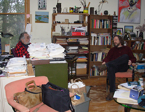 A photo of Robert Schoch and John Anthony West sitting and speaking with other
in JAW's home in New York