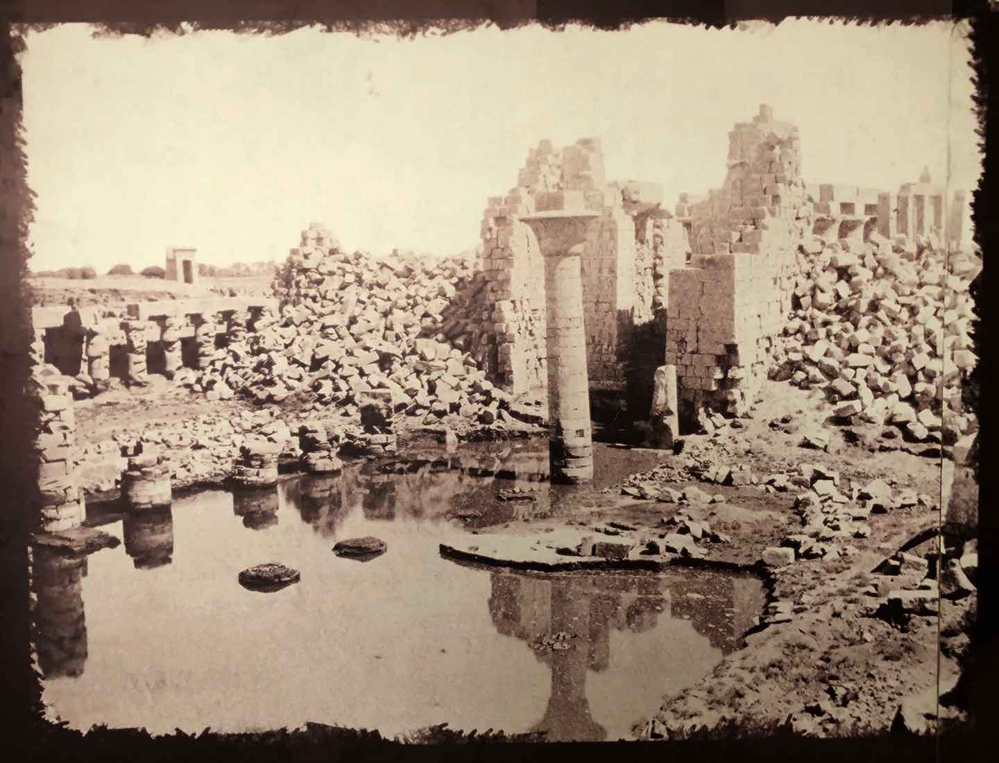Historical photo of Karnak Temple with massive rocks piled around the tallest structures