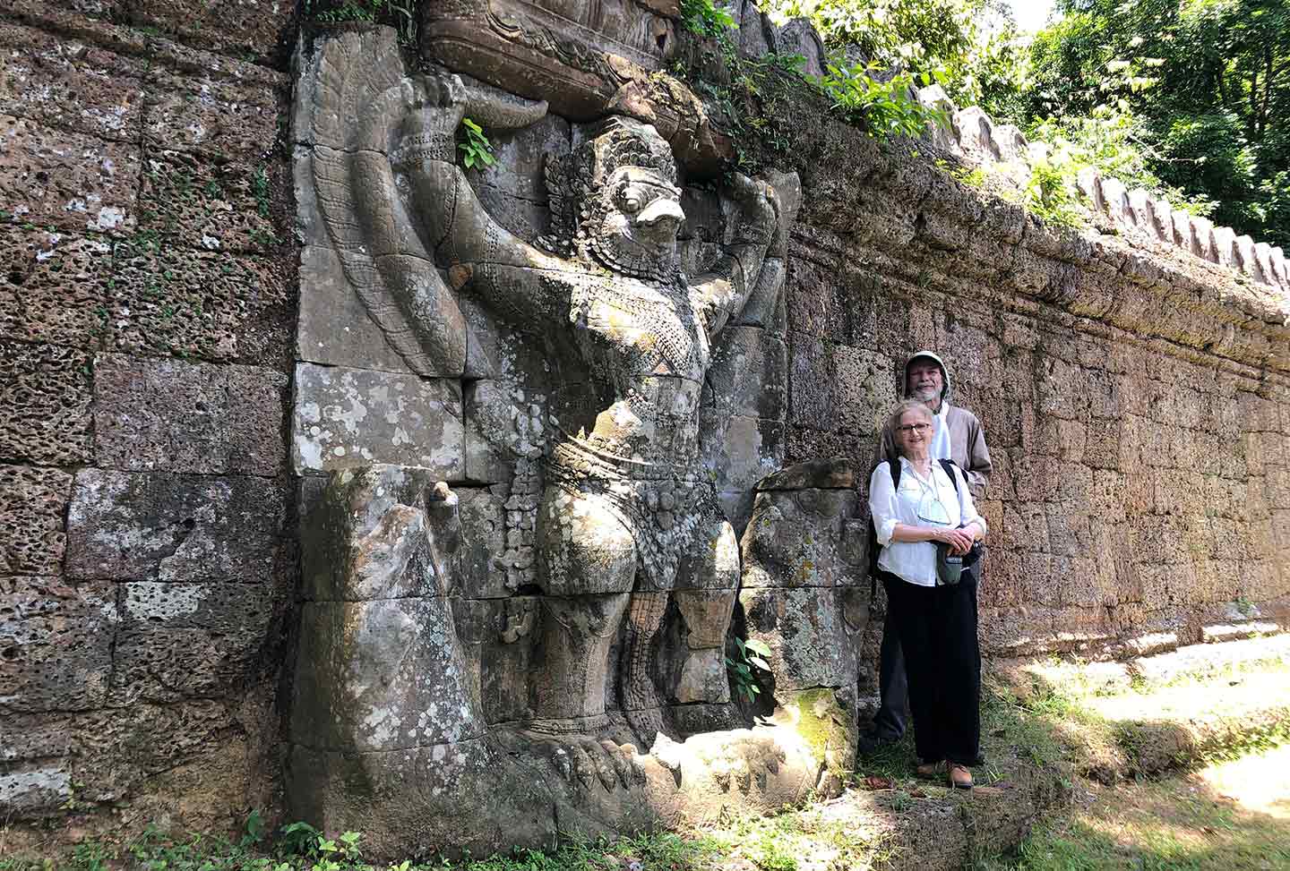 Robert Schoch and Catherine Ulissey beside the birdman called Garuda at the Preah Khan Temple of Angkor 
					in Cambodia
